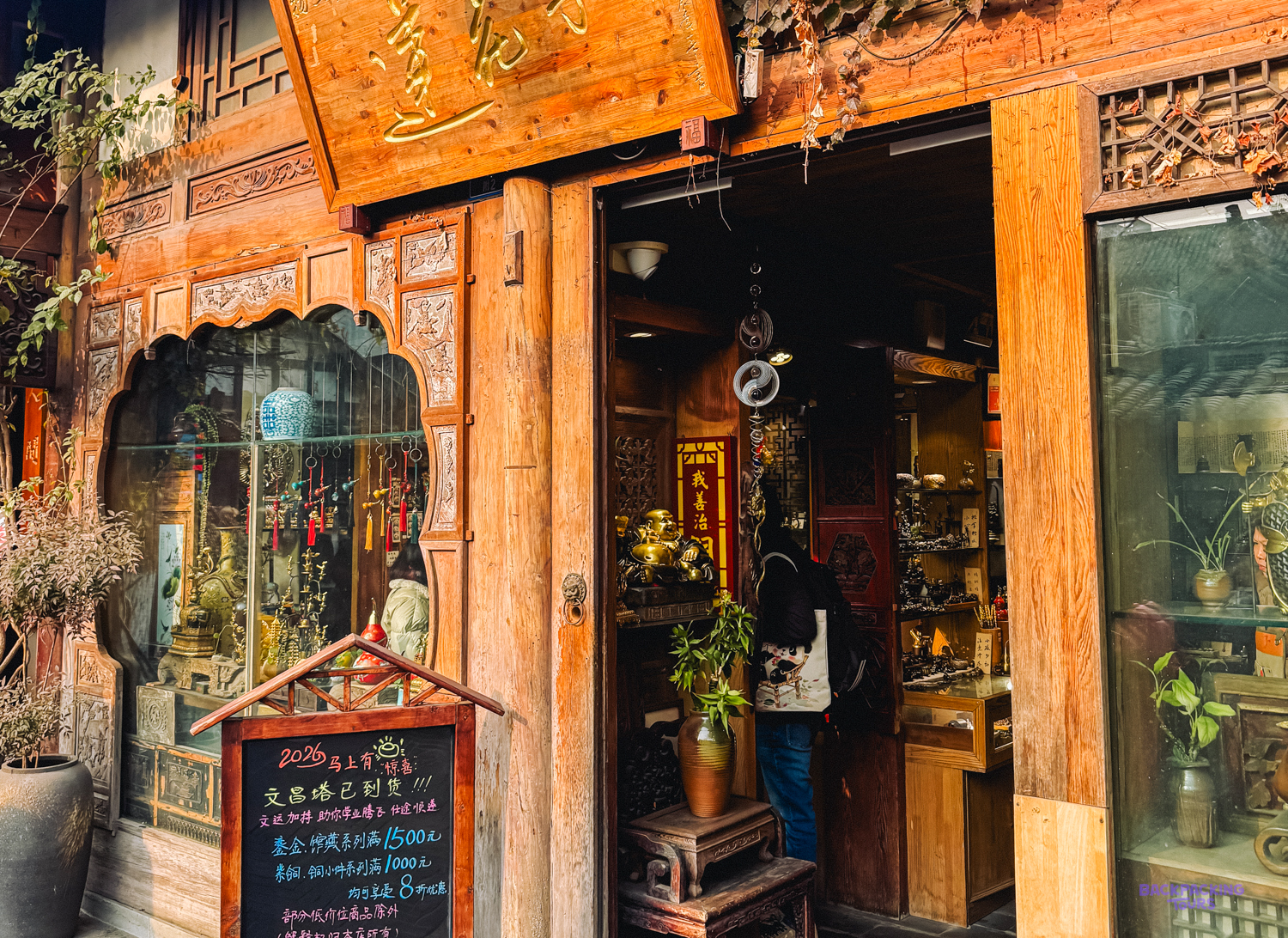 A person with a backpack browses inside a traditional wooden shop with intricate carvings in Chengdu.