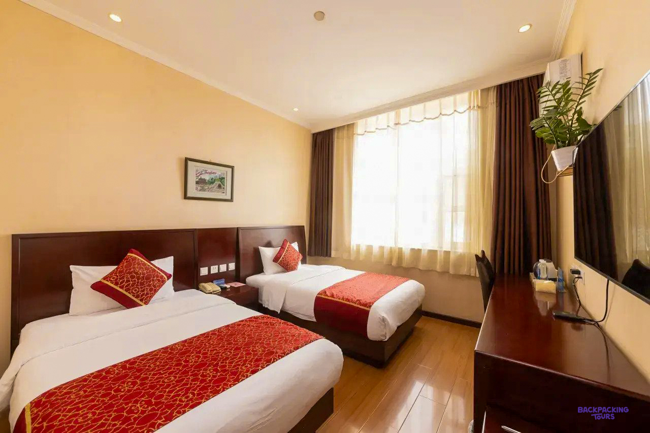 A twin room with red and white bedding at the hotel in Beijing