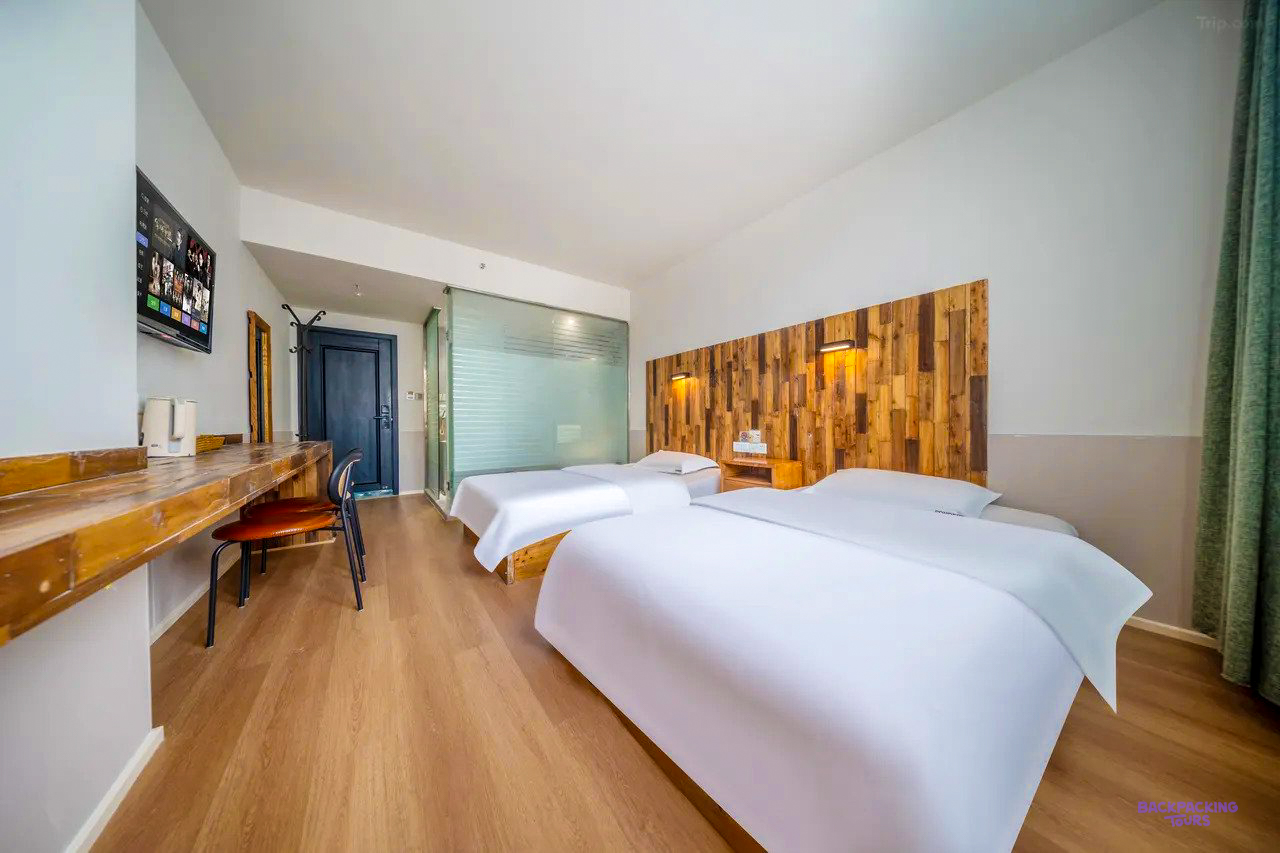 A bright twin room with a wooden feature wall at the accommodation in Chengdu