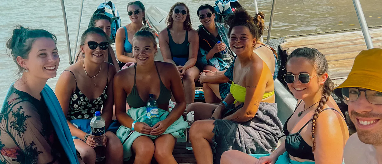 A joyful group of friends smiling on a boat trip near Cartagena, Colombia.
