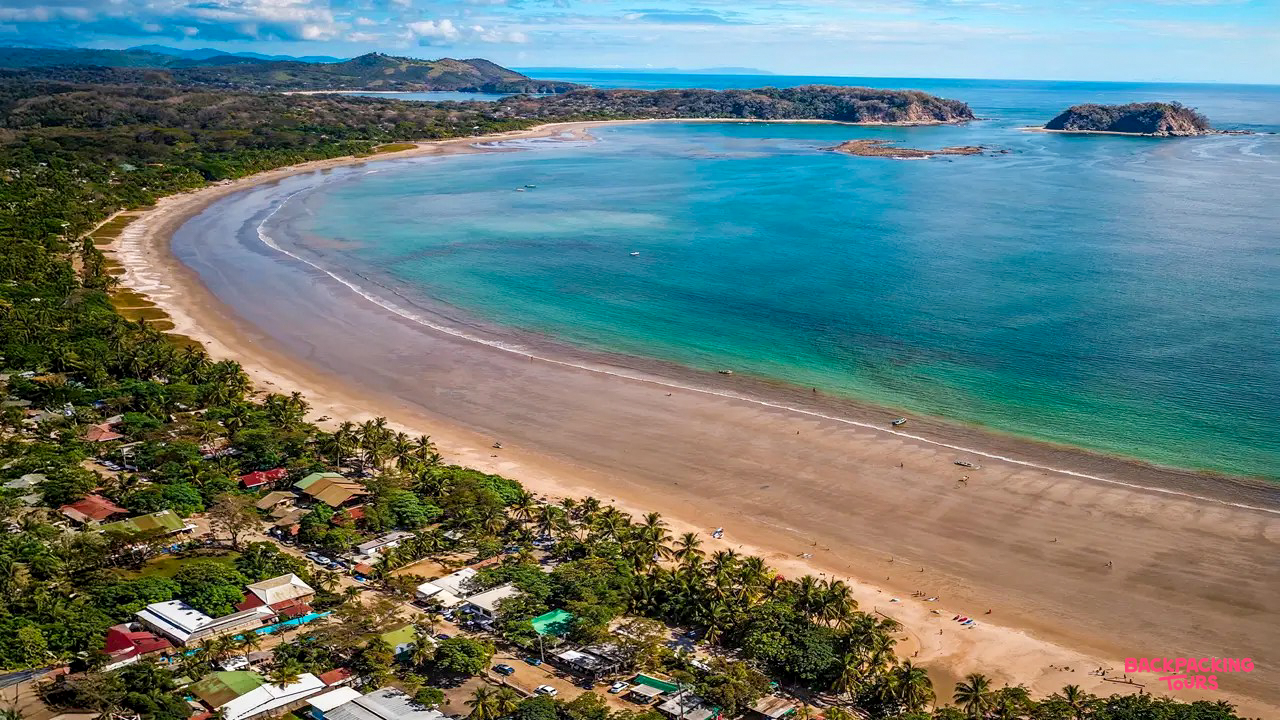 Beautiful aerial view of Samara beach in Costa Rica, with a wide sandy shore and clear turquoise ocean.
