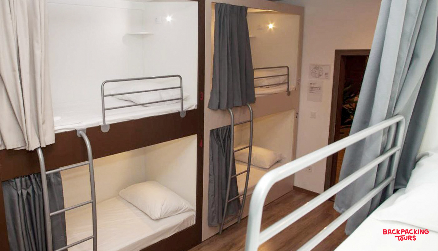 A clean and modern hostel dorm room in Split, Croatia, with multiple bunk beds and privacy curtains.