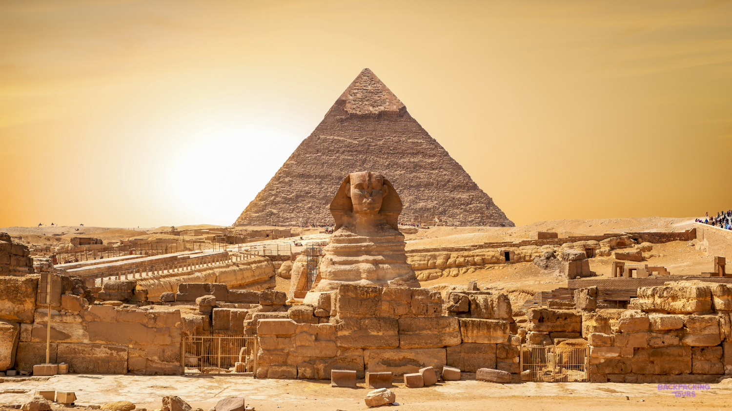 The majestic Great Sphinx and Great Pyramid of Giza stand under a golden sky in Egypt.