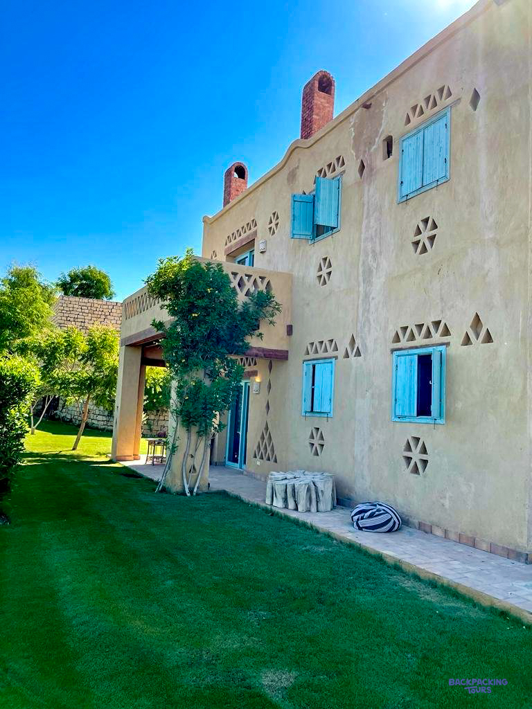 The earth-coloured walls and blue window frames of the lodge in Faiyum