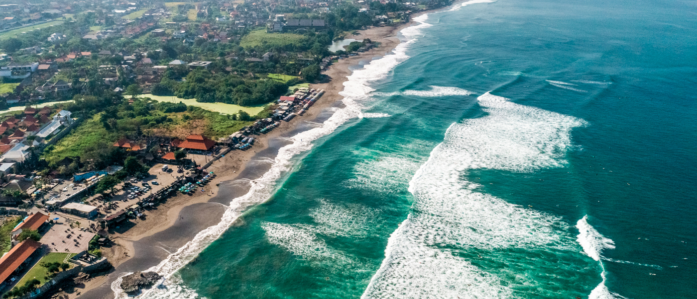 An aerial view of Kuta Lombok's vibrant coastline with a sandy beach and turquoise ocean waves.