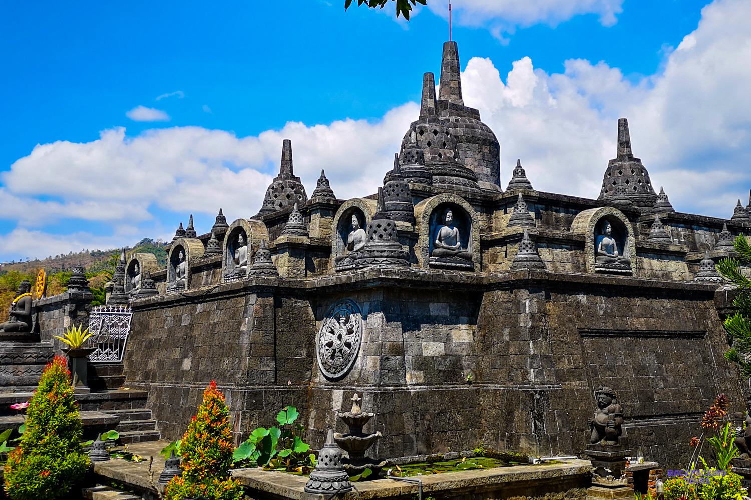 Stone stupas and seated Buddha statues on a terrace at a Buddhist monastery near Lovina.