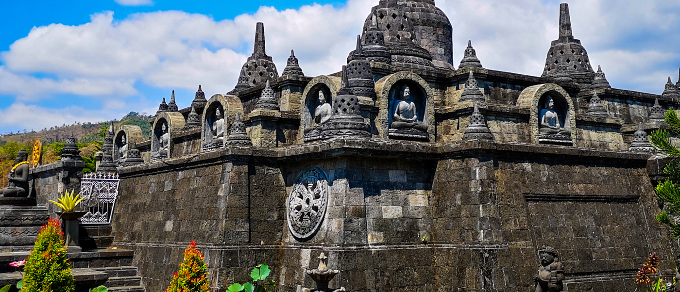 Stone stupas and seated Buddha statues on a terrace at a Buddhist monastery near Lovina.