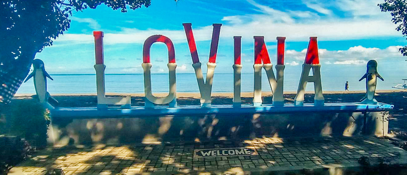 The giant red and white LOVINA letters on the seafront, with a dolphin statue either side.