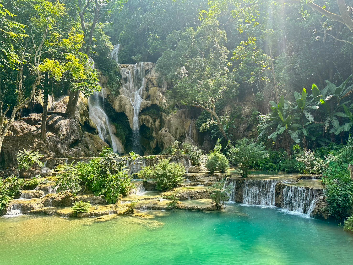 The main fall at Kuang Si drops through the jungle into a bright turquoise pool.