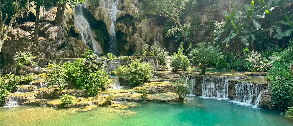 The main fall at Kuang Si drops through the jungle into a bright turquoise pool.