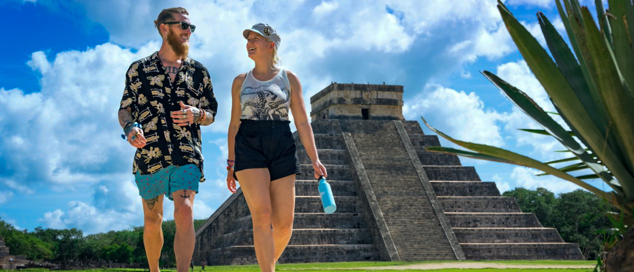 Two tourists walk past the ancient Mayan pyramid El Castillo at Chichén Itzá, Mexico.