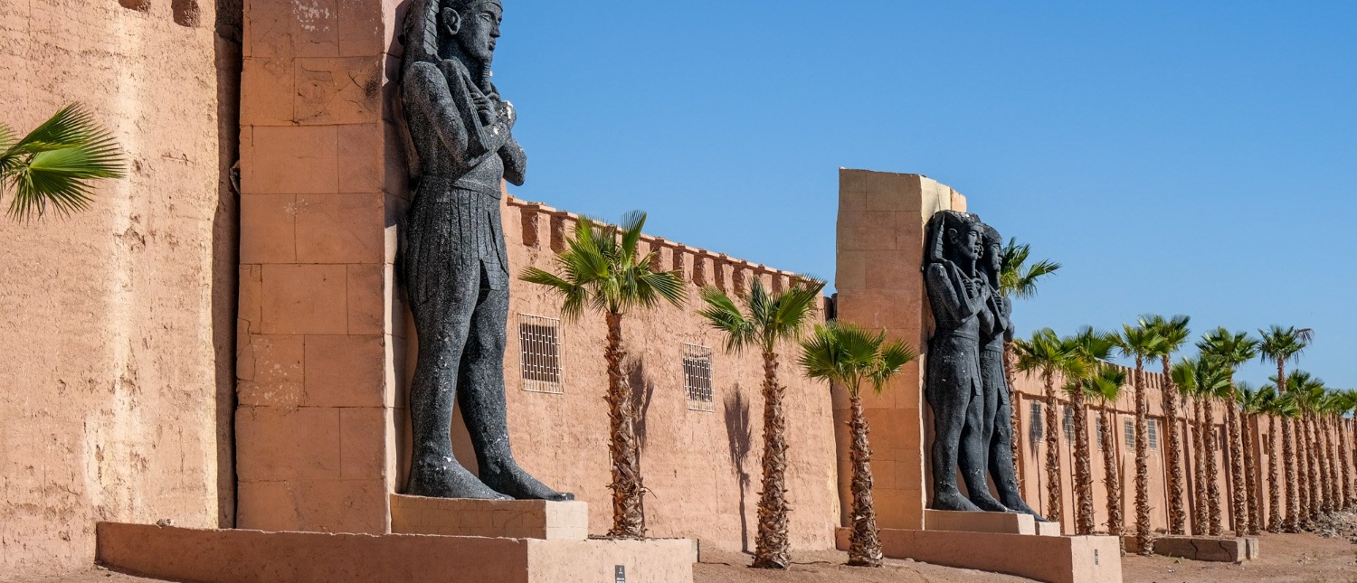 Ancient Egyptian-style statues and a fortified wall at Atlas Studios in Ouarzazate, Morocco.