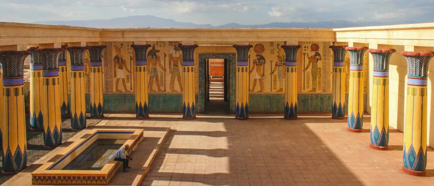 A person relaxes by a pool in an elaborate ancient Egyptian movie set at Atlas Studios.
