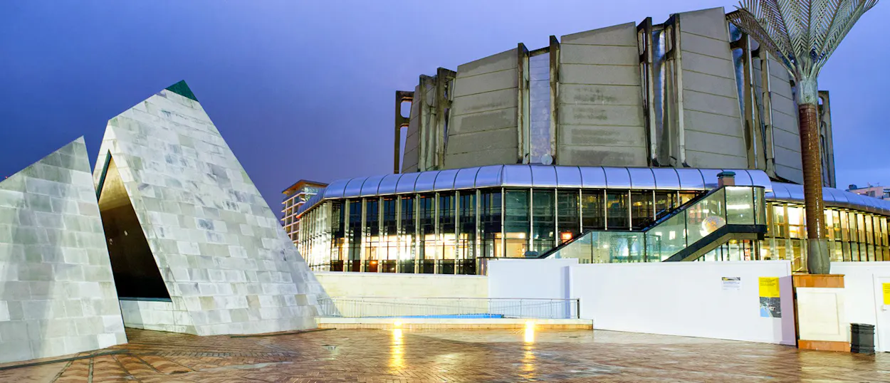 The striking modern architecture of Te Papa museum in Wellington at dusk, with illuminated facades.