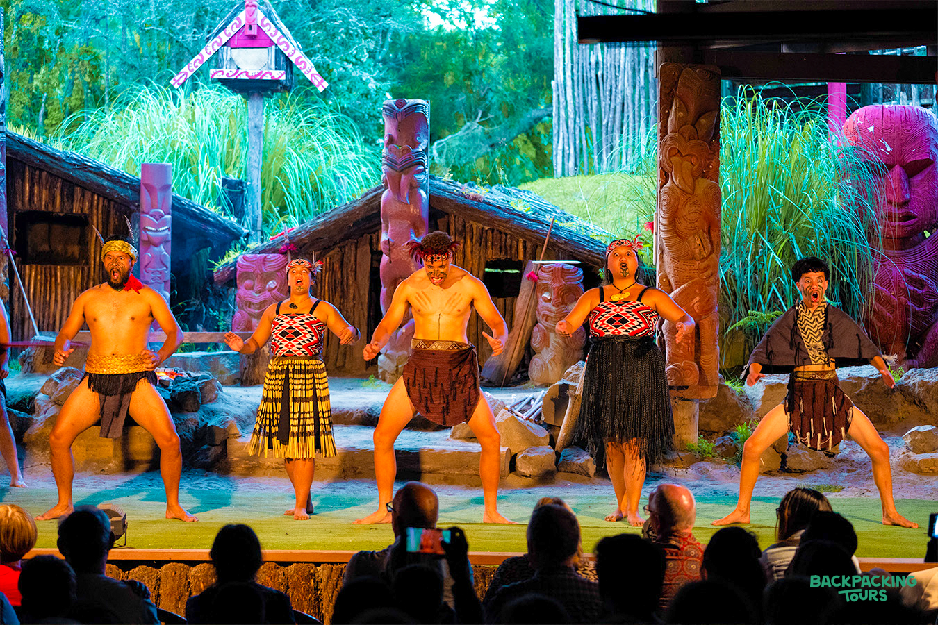 Māori performers in traditional dress engage the audience with a vibrant cultural show in Rotorua.