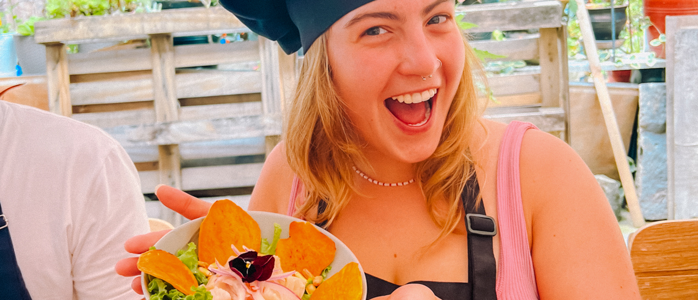 Smiling woman in a chef's hat proudly displays her Peruvian ceviche dish in Cusco.