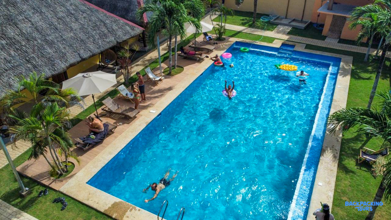 People swim and relax by the clear blue pool at a tropical resort in Bohol.