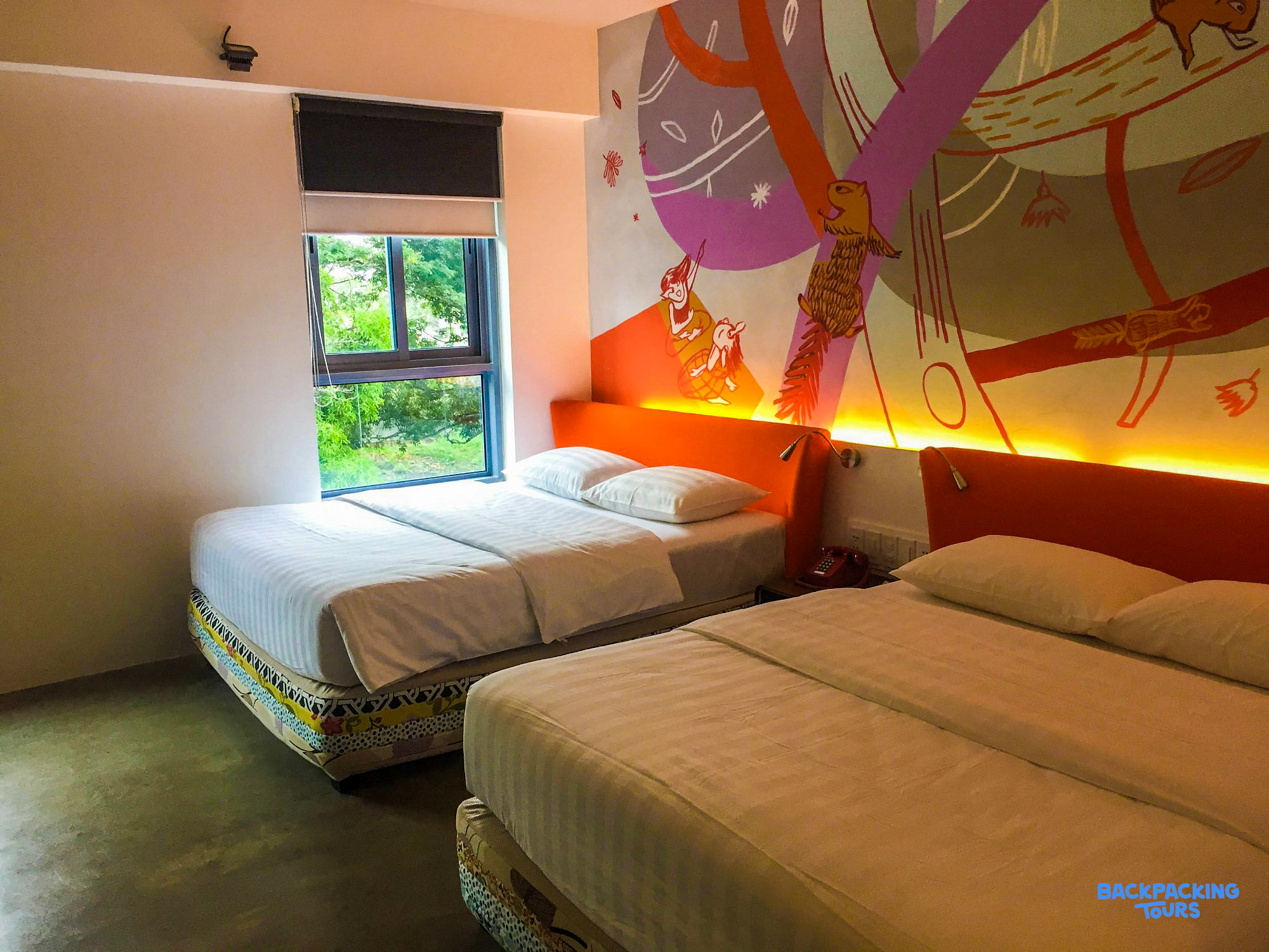 A bright and modern hotel room in Puerto Princesa with two comfortable beds and a colorful wall mural.