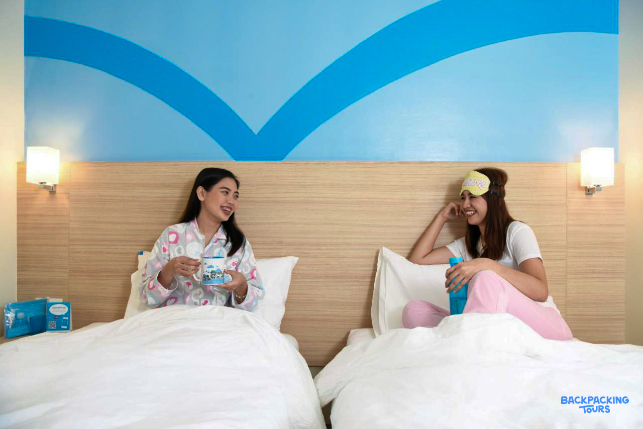 Two friends relax and chat in their comfortable hotel room after exploring Cebu City.