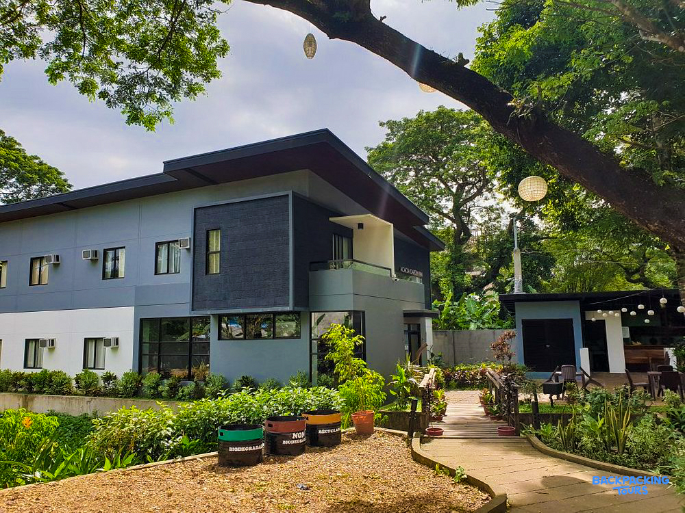 The modern Acacia Garden Inn accommodation in Coron, nestled among green trees and plants.