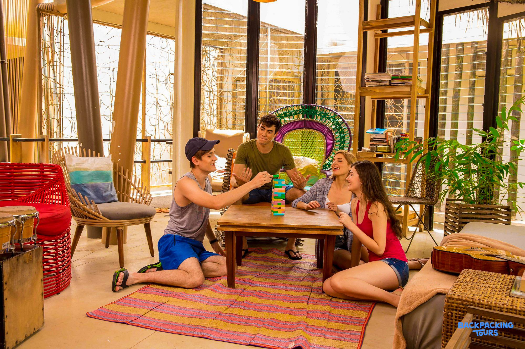 Friends enjoy a game of Jenga in the relaxed common area of their El Nido hostel.