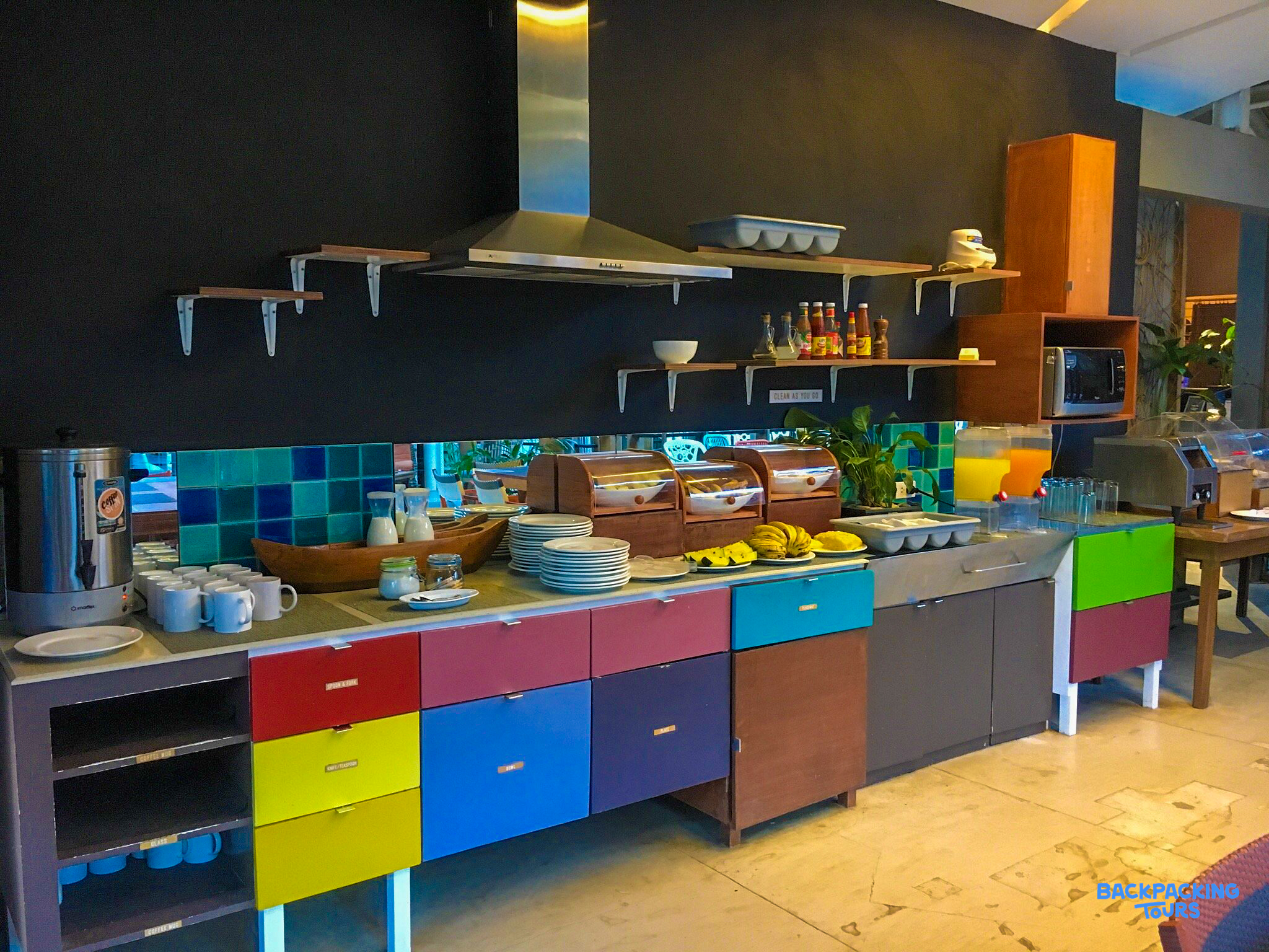 Enjoy a vibrant breakfast buffet with colorful drawers and various food options at your El Nido hostel.
