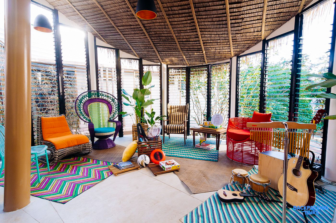 Bright and inviting common room with colorful seating, rugs, and musical instruments in El Nido.