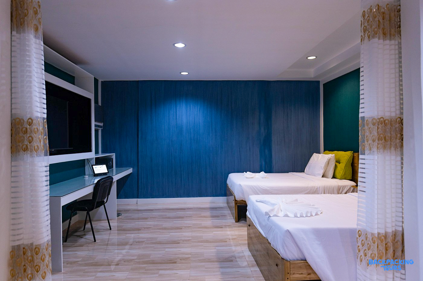 A modern and clean twin room in Moalboal with comfortable beds and a workspace.