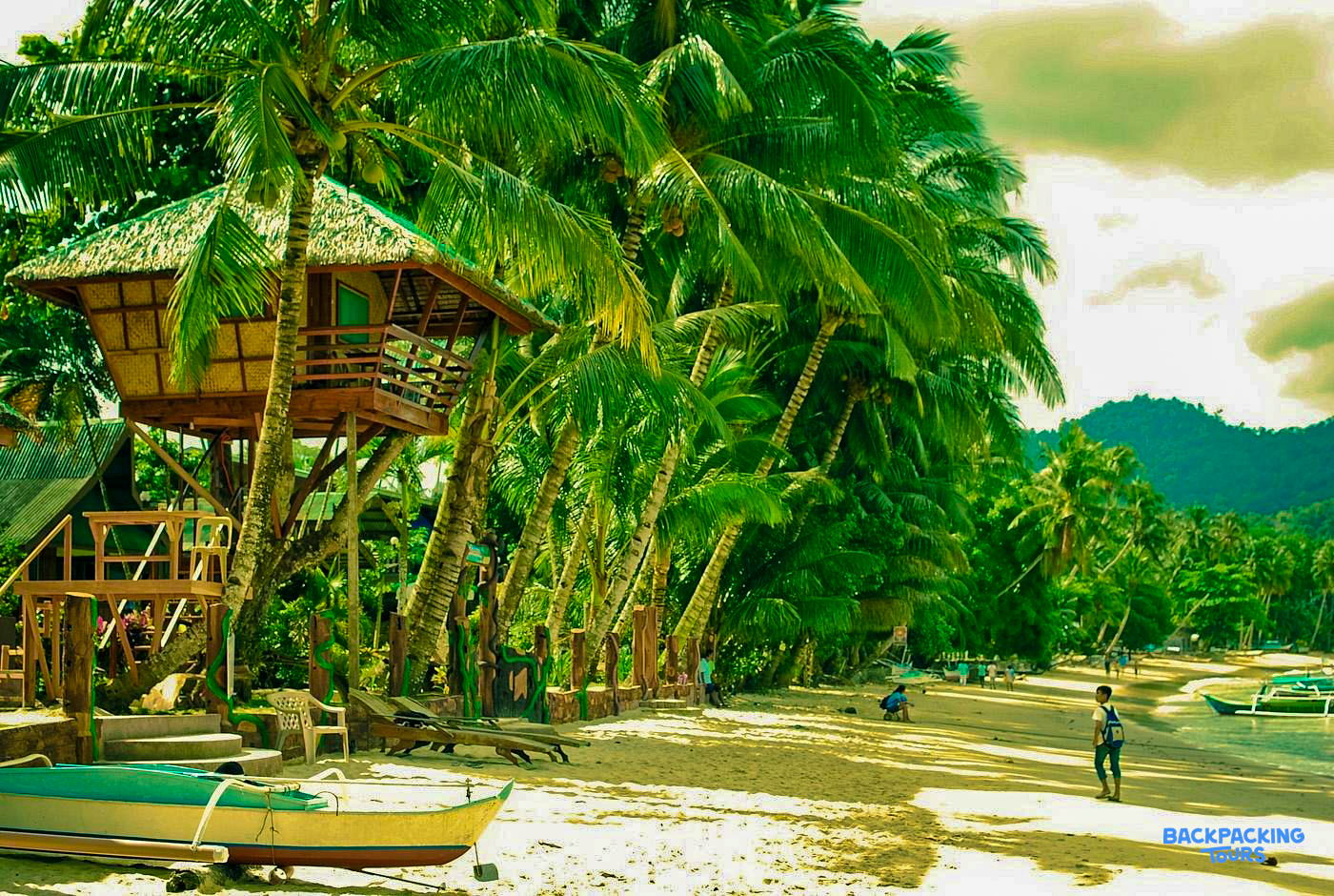 A charming treehouse accommodation on a sandy beach with swaying palm trees in Port Barton.
