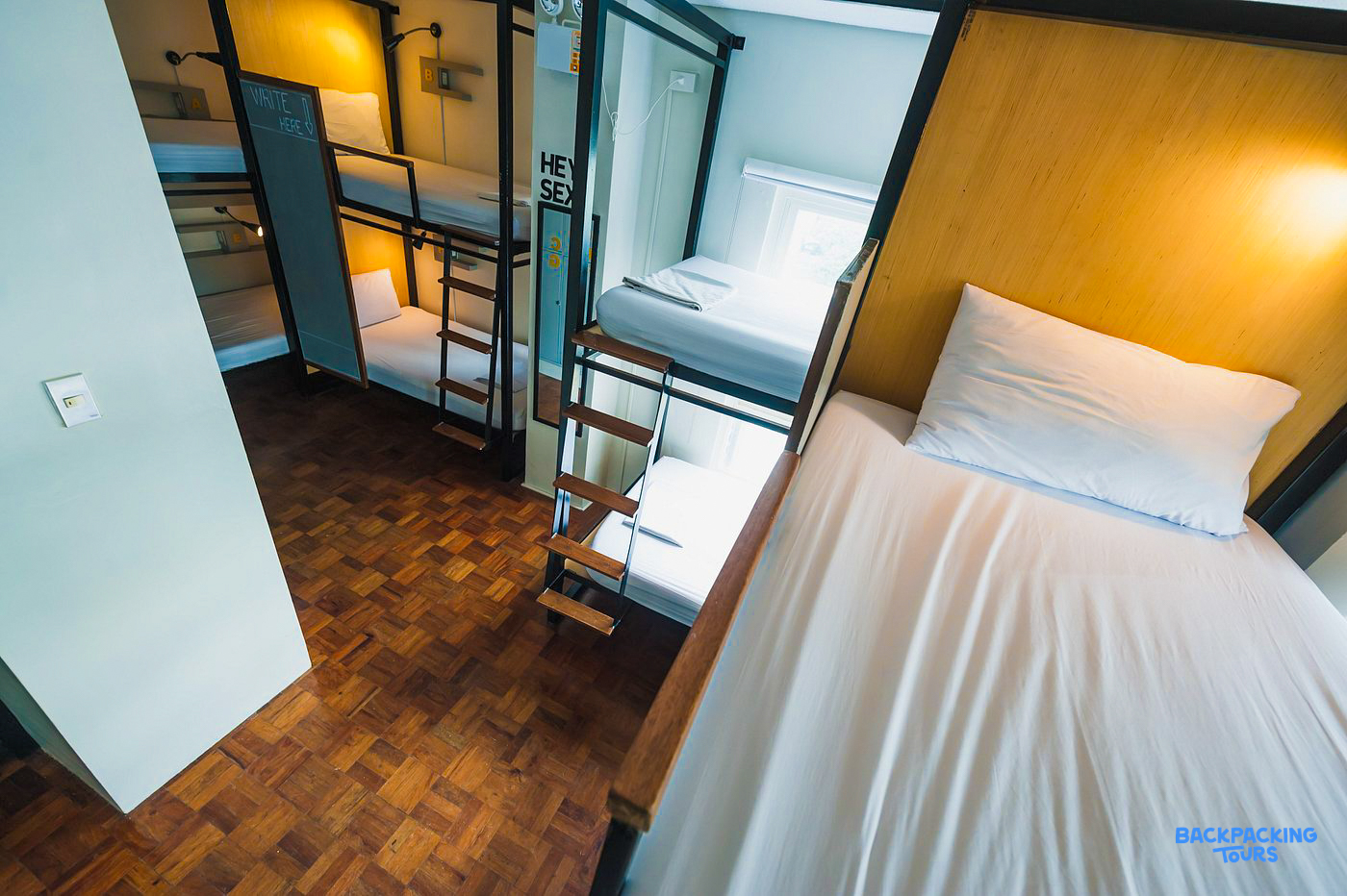 Modern bunk beds in a clean, well-lit hostel dorm room in Manila, ready for backpackers.