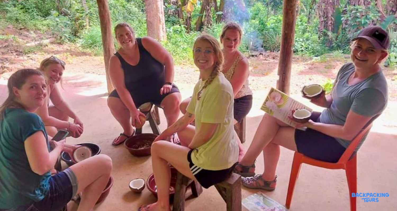Smiling women learn to prepare coconuts for cooking traditional Filipino dishes in El Nido.