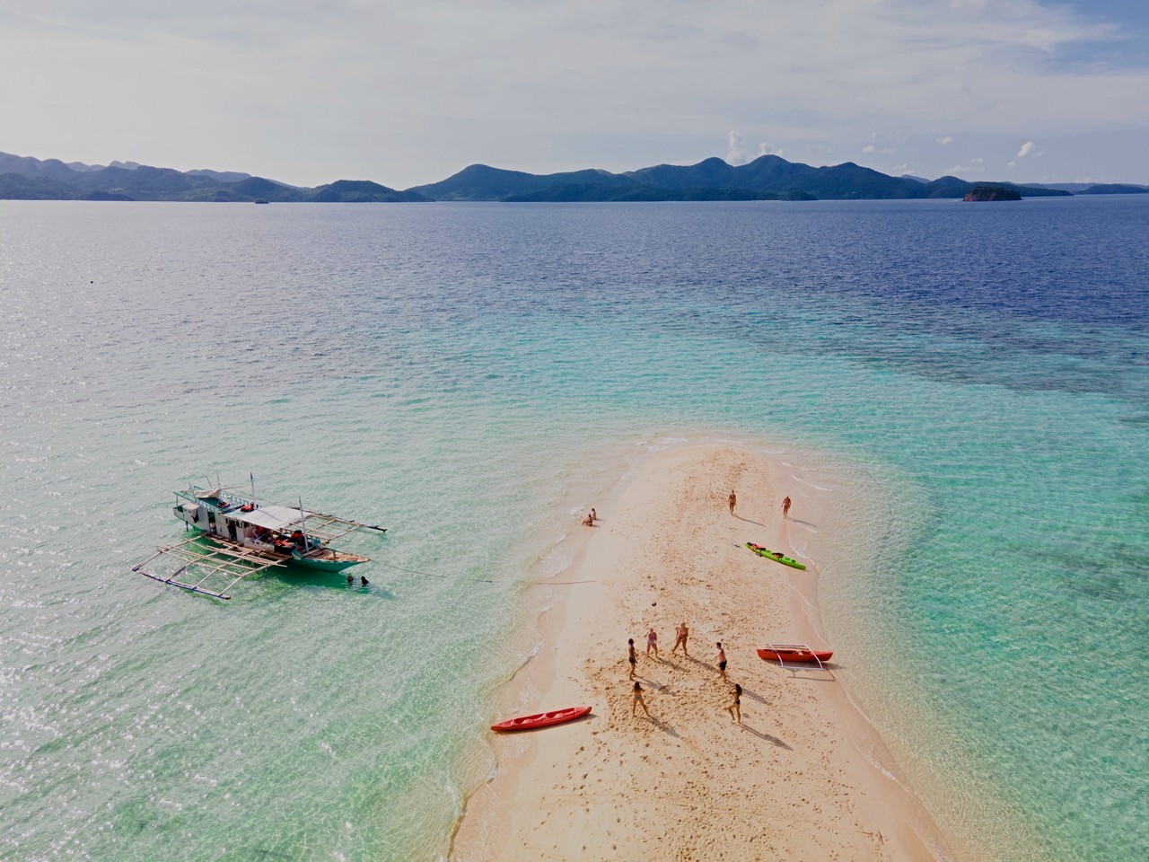 An aerial view of a white sand bar surrounded by turquoise water in Palawan.