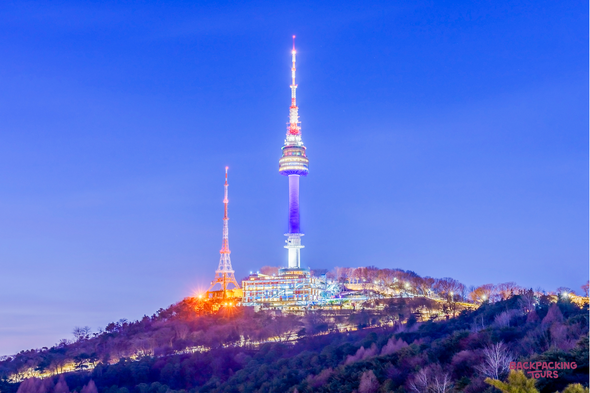 The iconic N Seoul Tower illuminates the Seoul skyline from Namsan mountain at twilight.