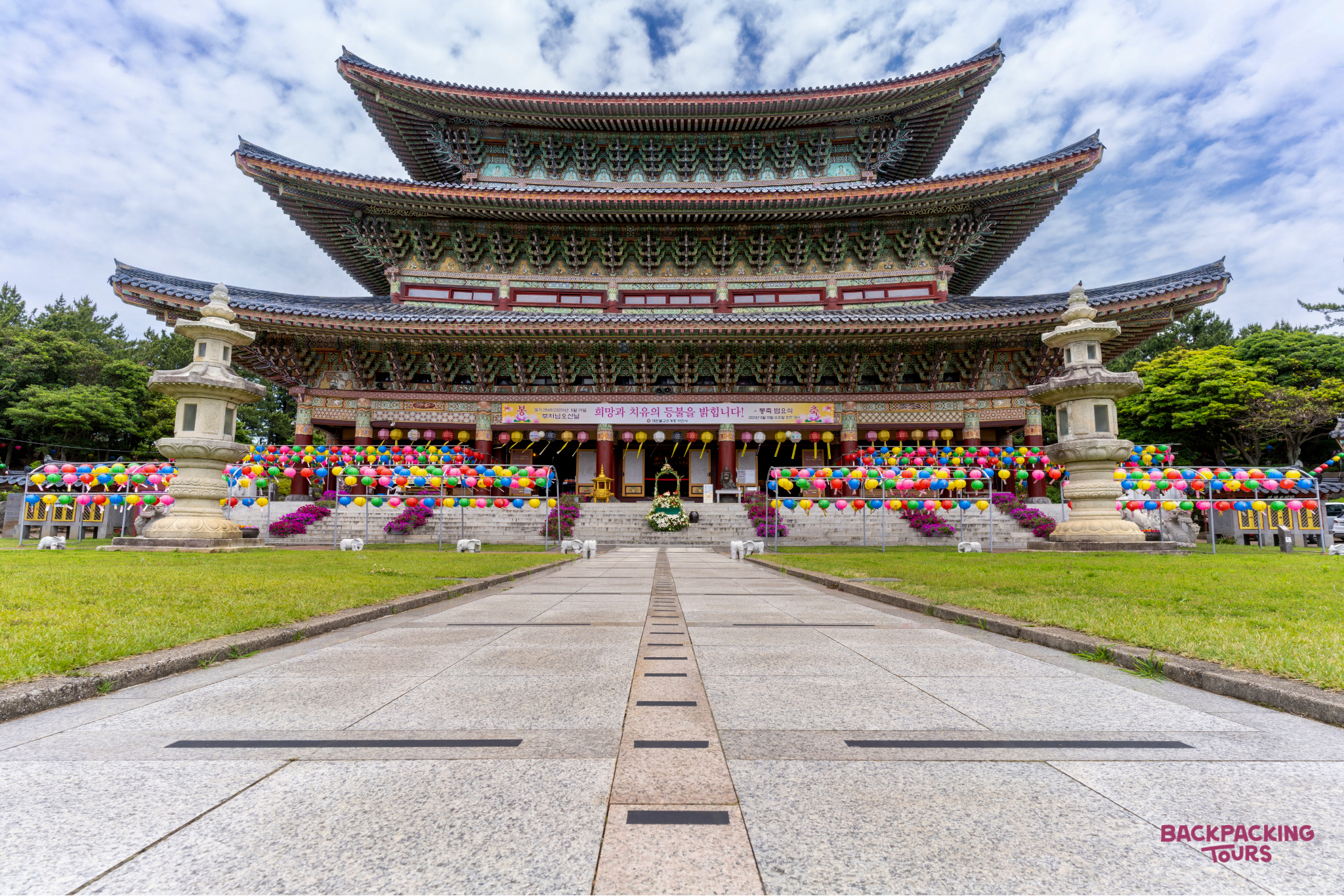 The grand Yakcheonsa Temple on Jeju Island, decorated with vibrant lanterns for a celebration.