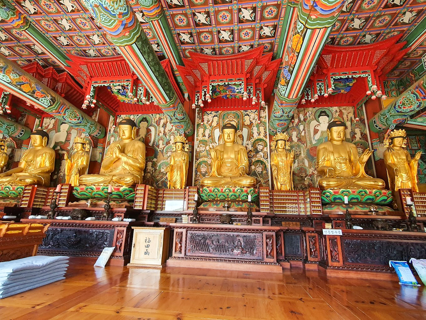 Golden Buddha statues sit peacefully inside the beautifully decorated Geumsunsa temple in South Korea.