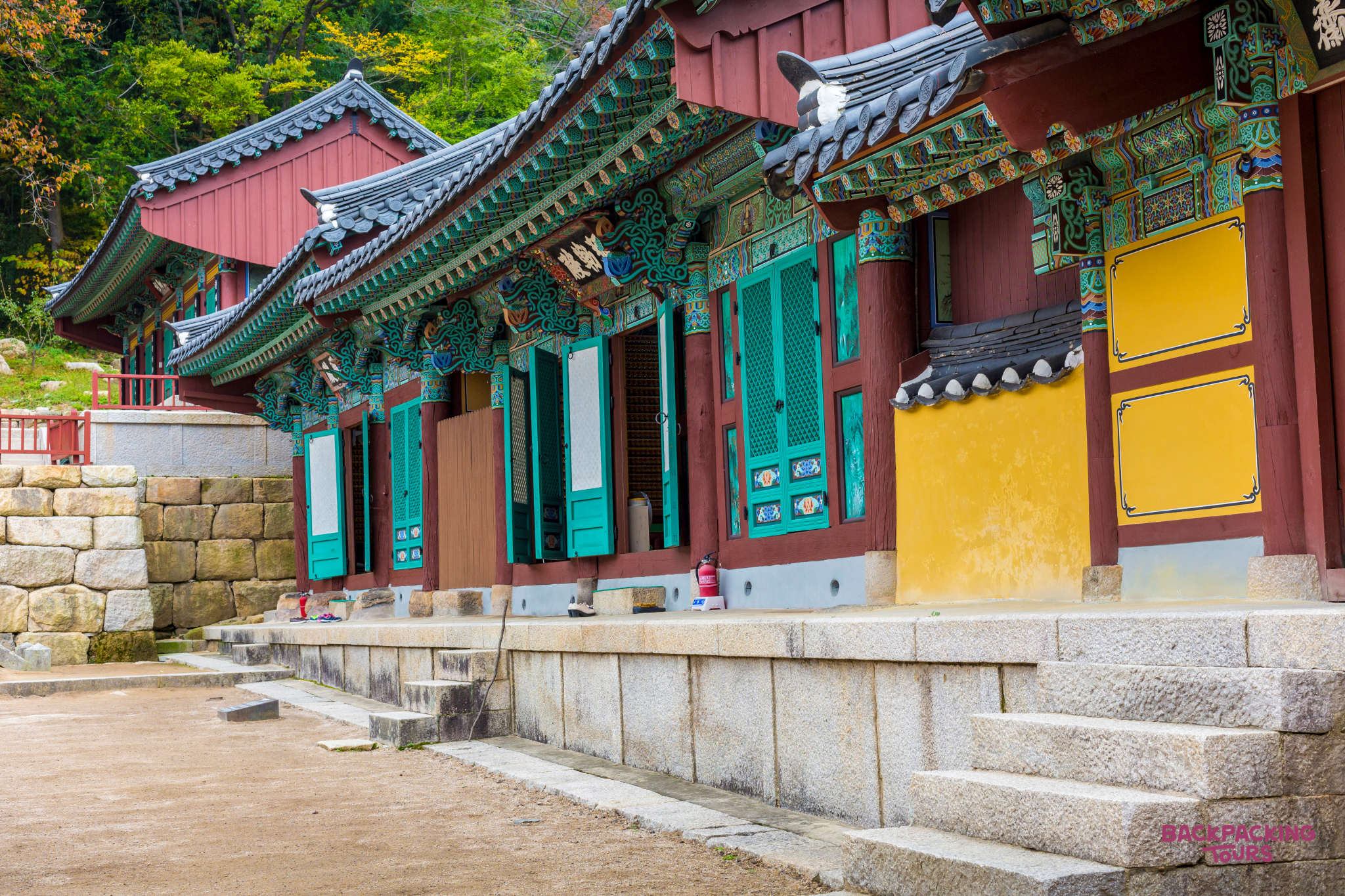 Vibrant traditional Korean temple architecture with intricate painted eaves and green window shutters at Geumsunsa.