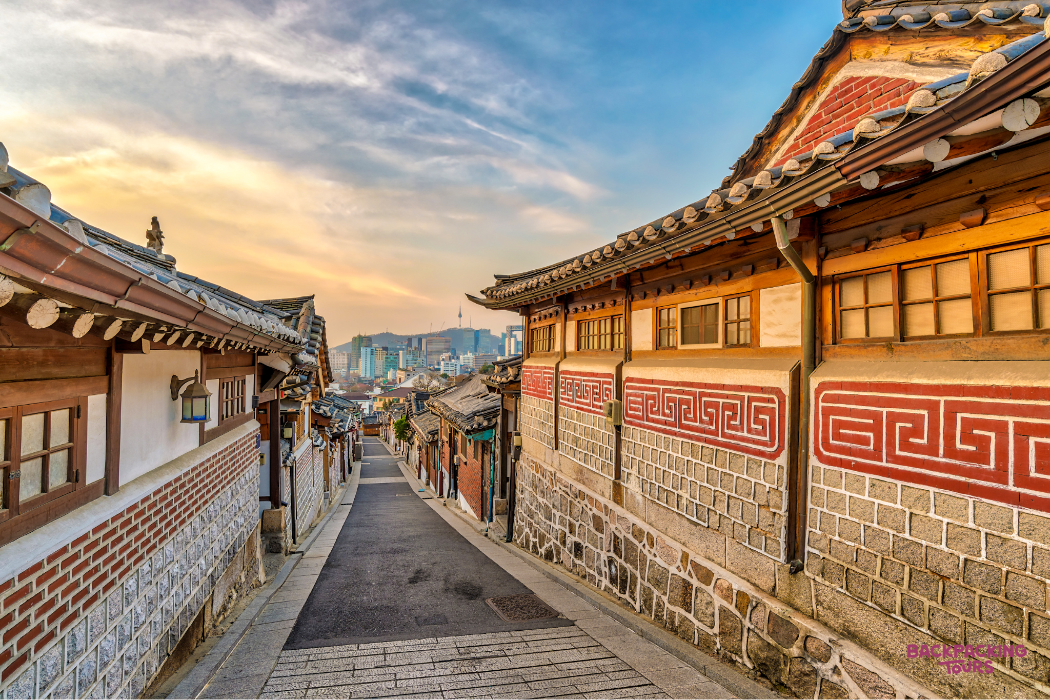 Traditional Hanok houses with patterned walls line a quiet street in Jeonju, South Korea.