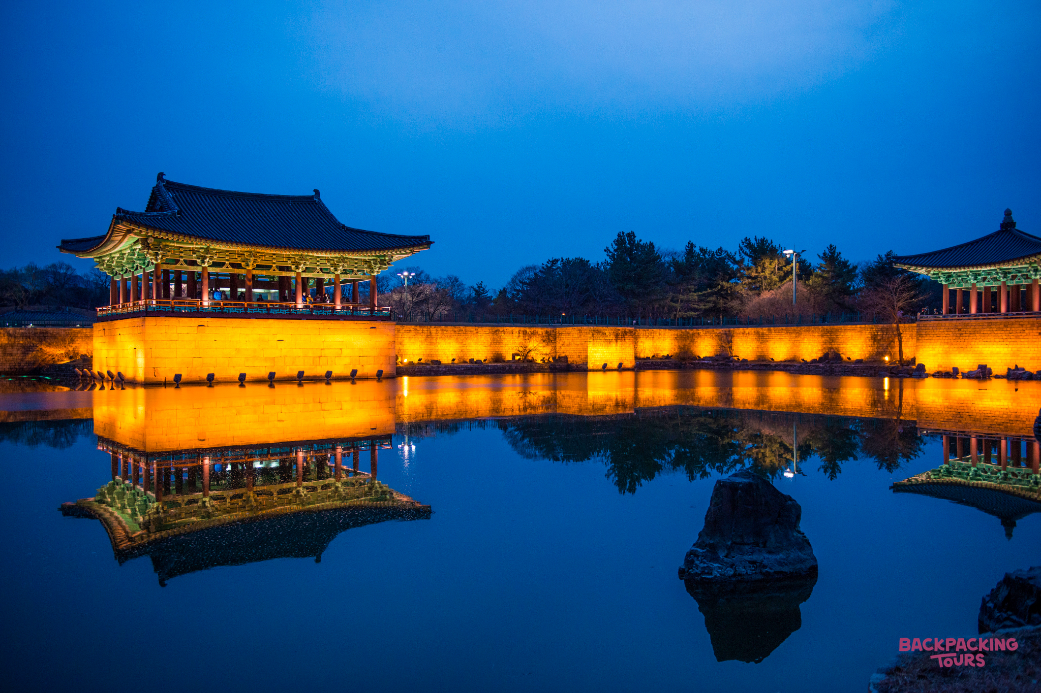 Gyeongju's ancient Donggung Palace and Wolji Pond beautifully illuminated at night, reflecting in the still water.