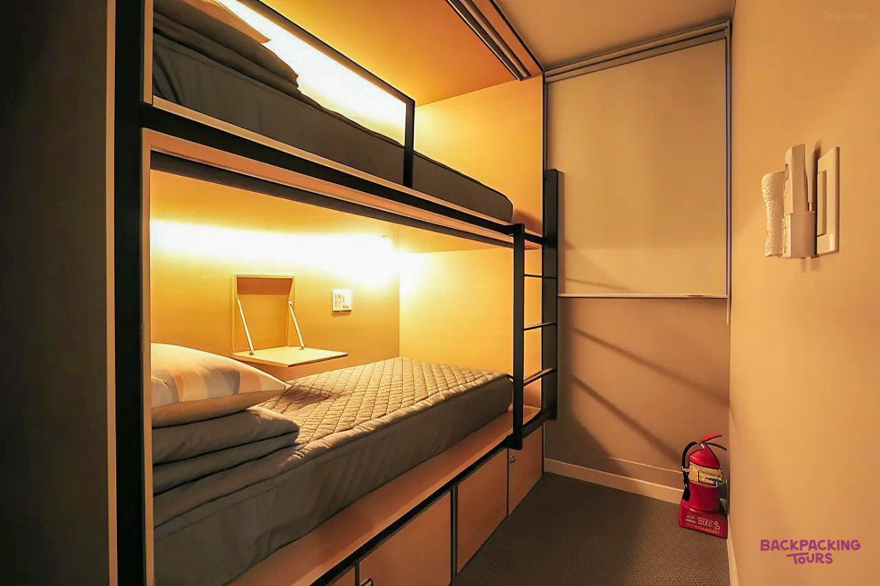 A modern hostel bunk bed room in Gyeongju, South Korea, with individual lights and storage.