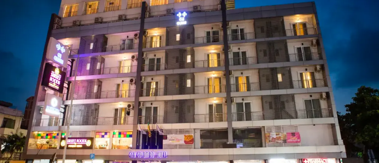 A modern hotel building with many balconies and illuminated windows at night in Colombo.