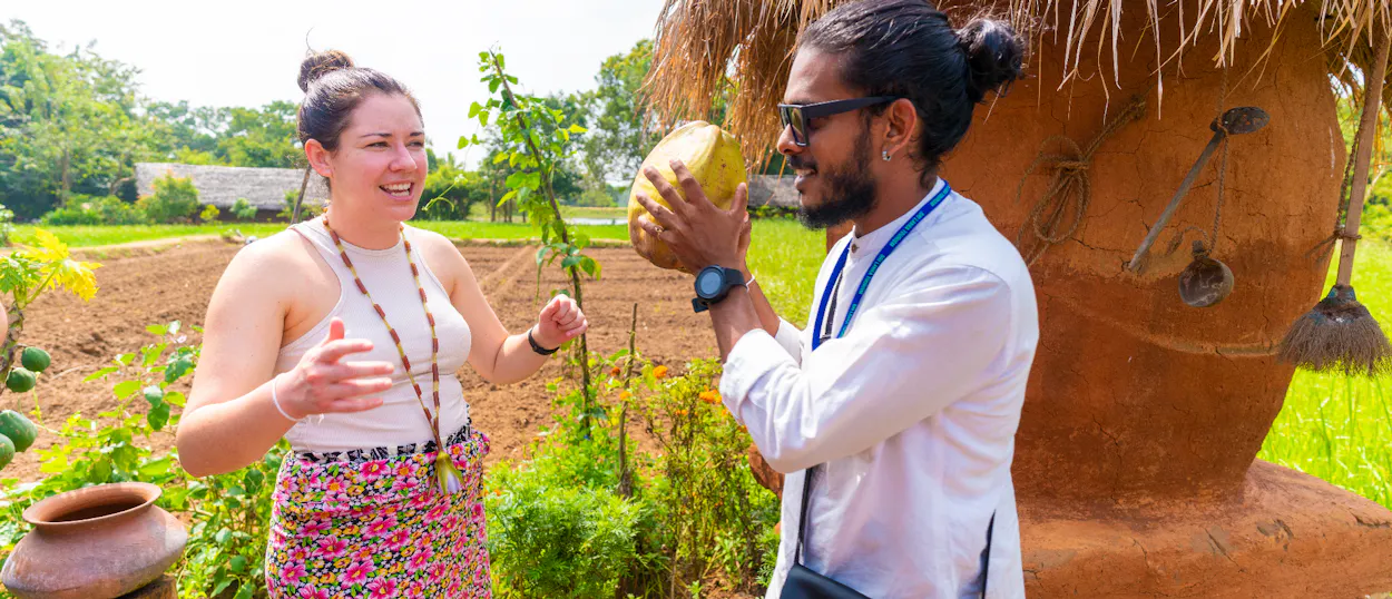 A man offers a coconut to a woman during a village tour in Sigiriya, Sri Lanka.