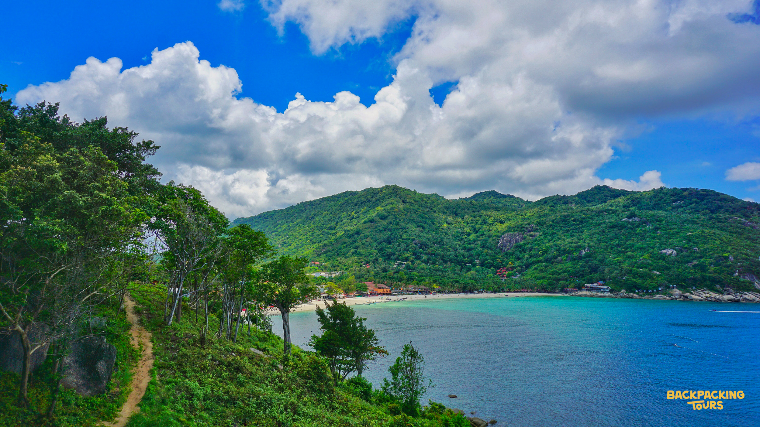 Lush green hills and clear turquoise water define this beautiful tropical bay on Koh Phangan.