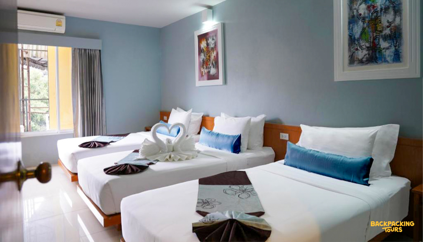 A clean and inviting triple room at a guesthouse in Bangkok, ready for your stay.