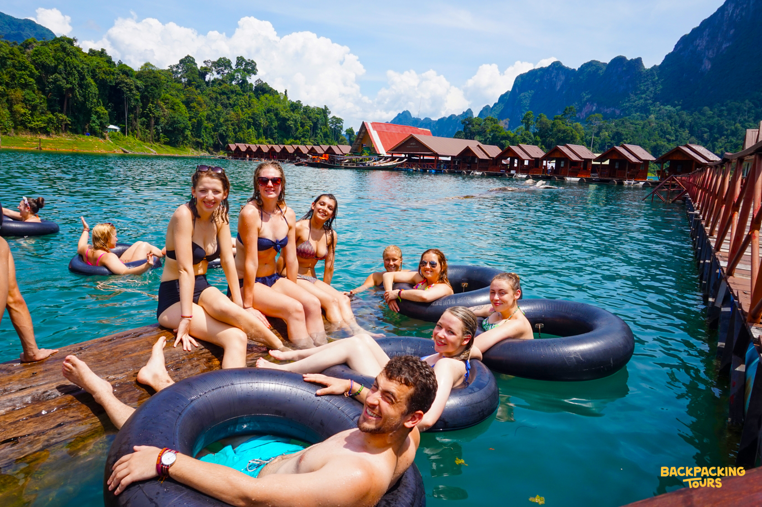 Backpacking group relaxing on inflatable tubes on Cheow Lan Lake at Khao Sok floating bungalows