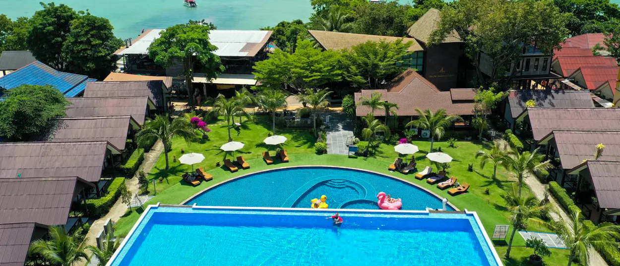 Guests relax by two swimming pools at a tropical resort on Thailand's Phi Phi Islands.