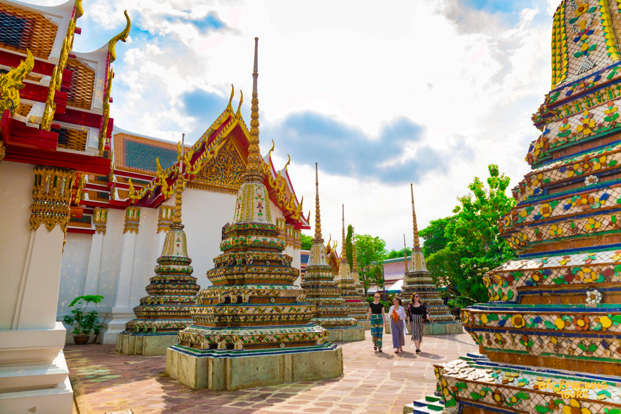 Backpacking tour group exploring Wat Pho temple on Bangkok tuk-tuk tour