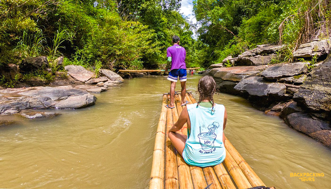 Bamboo rafting down a tranquil river in Chiang Mai with the backpacking group during the bamboo rafting adventure