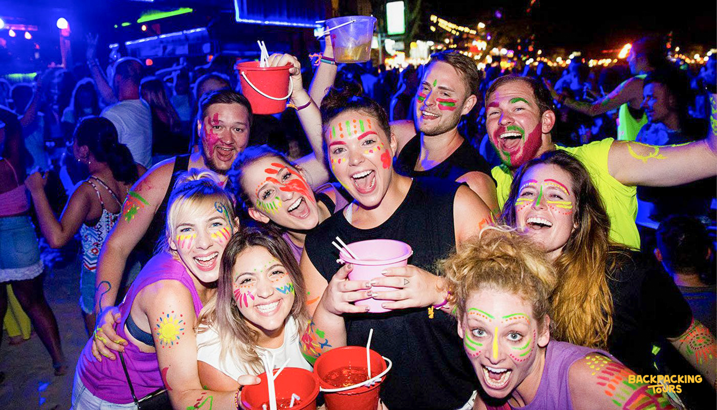 Backpacking group having fun at a lively beach party on Koh Phi Phi after arriving on the island