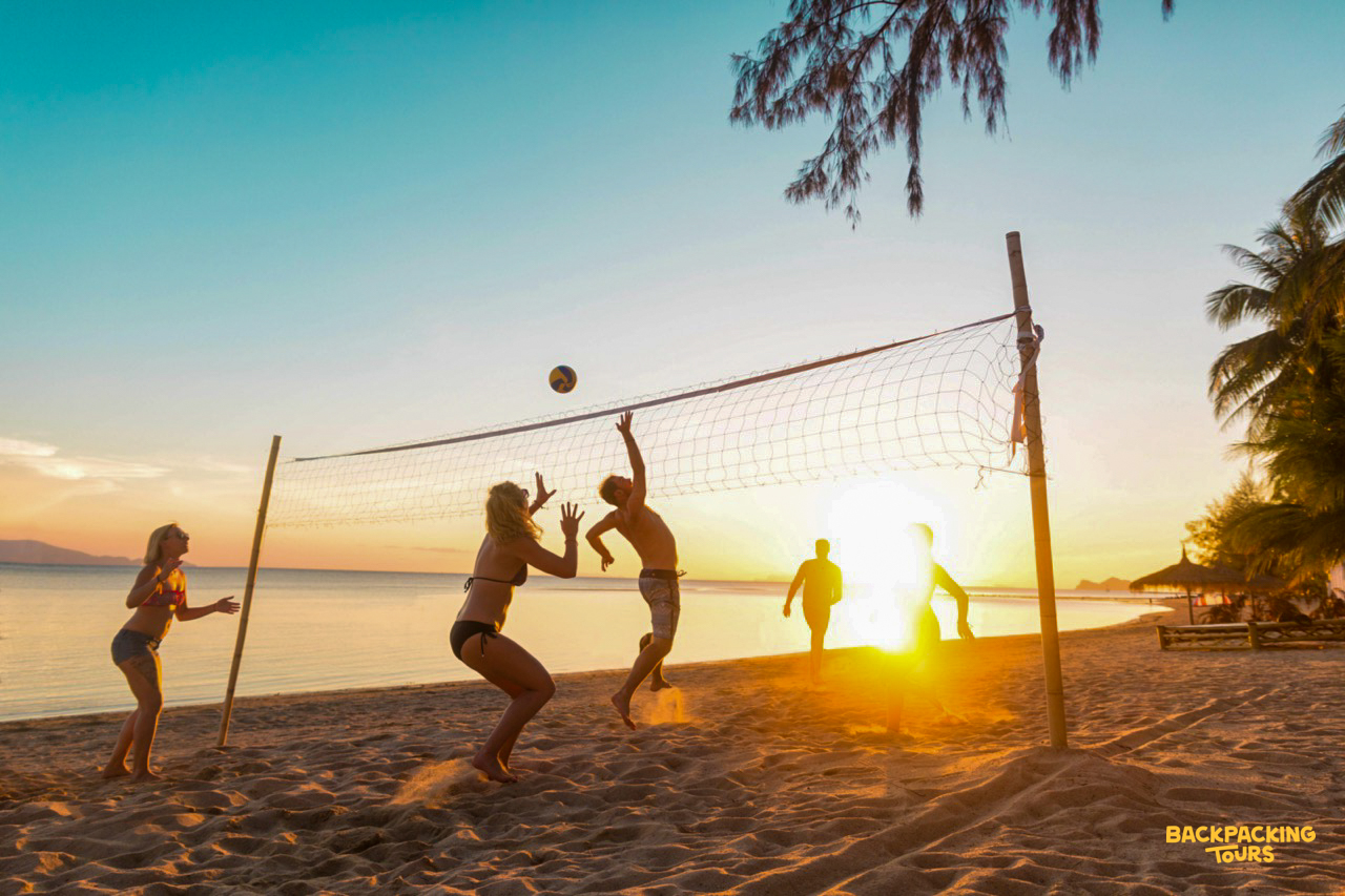 Backpacking group playing volleyball on the beach in Koh Phangan during a relaxed beach day