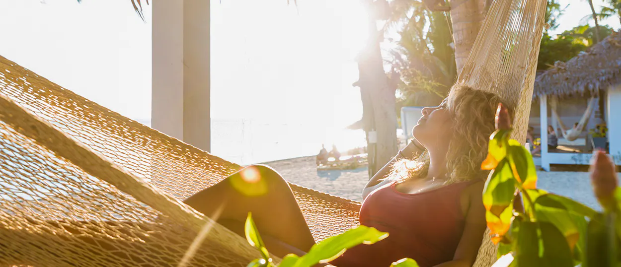 Blonde woman relaxing in a hammock on a beautiful, sun-drenched beach in Koh Phangan.